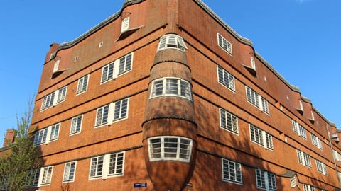 Het Schip, complexo de habitação social da Escola de Amesterdão (1919-21), com a torre em tijolo em forma de proa de navio na esquina.